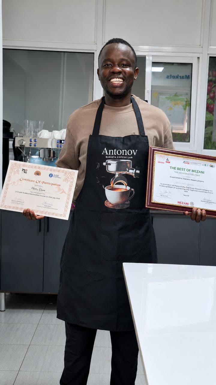 An Antonov graduate holding his coffee-grading certificate and a Best of Mezani espresso award